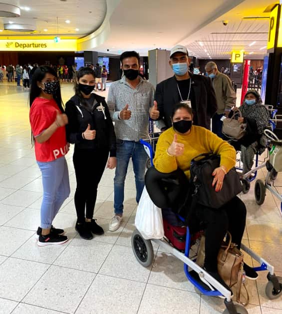 Atul Abrol (back row extreme right) with passengers ready to board a chartered flight to India.