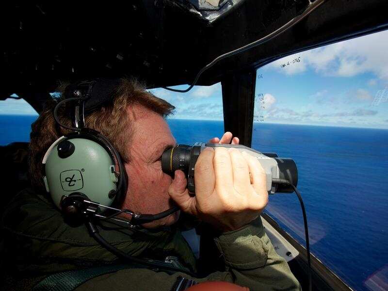 An air force spotter looks out for missing Malaysia Airways MH370