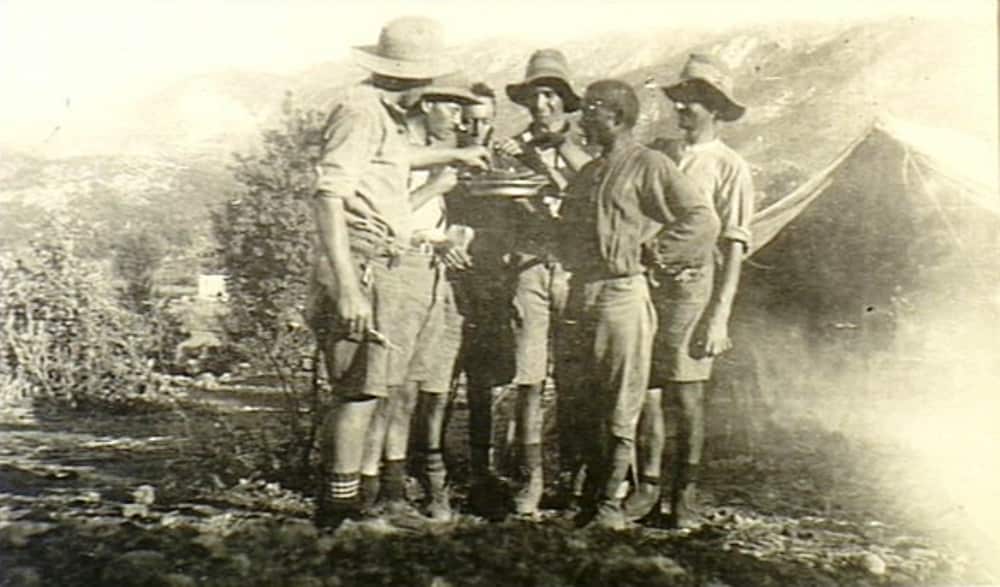Kurdistan. 1919. Four members of `D' Troop, 1st Wireless Signal Squadron, Mesopotamian Expeditionary Force, share a plate of round Indian bread chapattis offered to them by an Indian soldier in the outdoors.