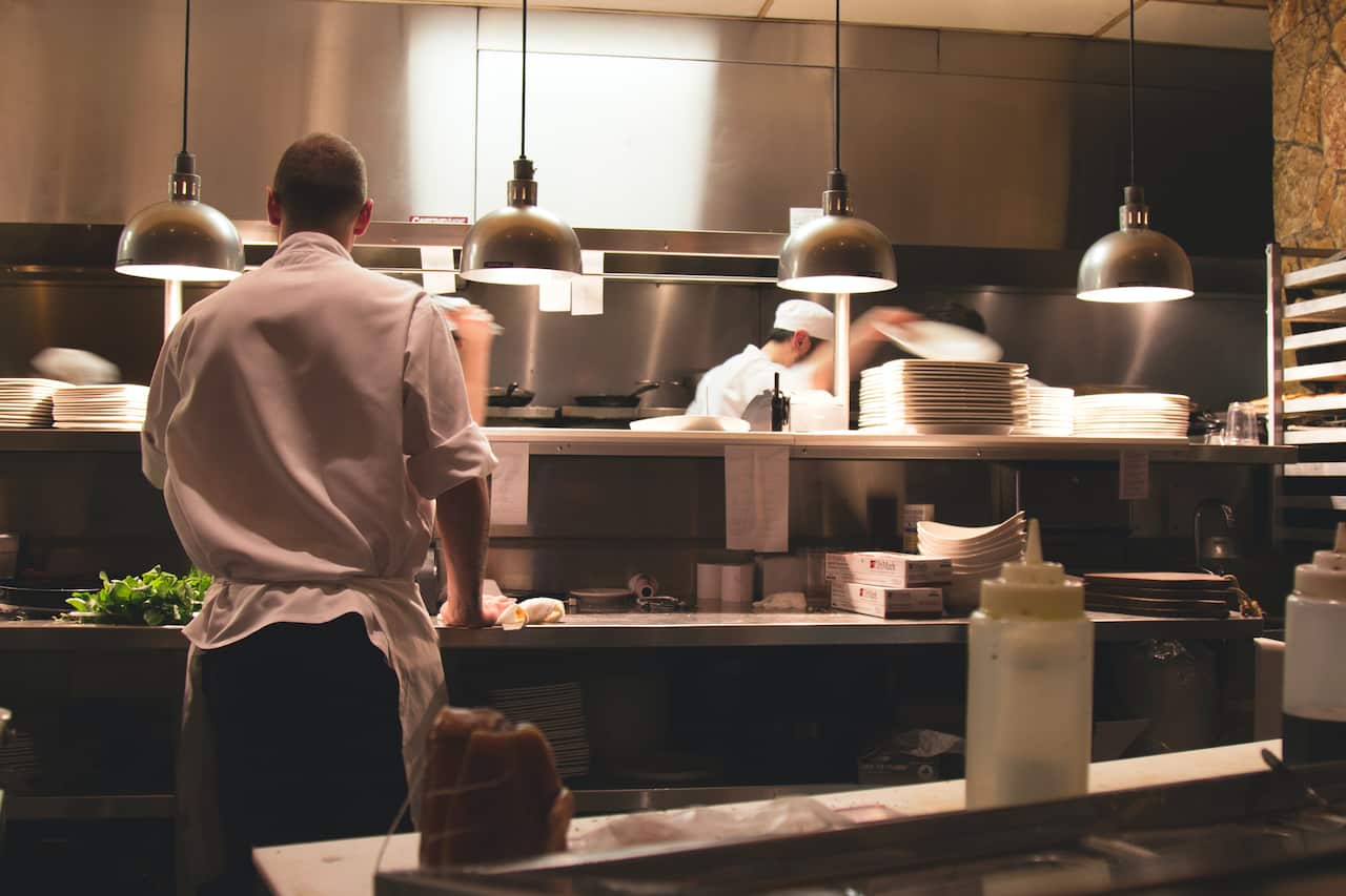 Chef and staff working in kitchen