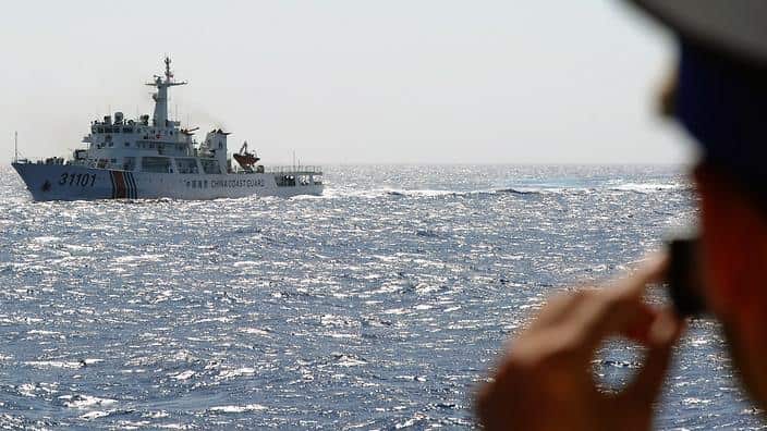 Vietnamese coast guard officer taking picture of a China Coast Guard ship  at the disputed water 