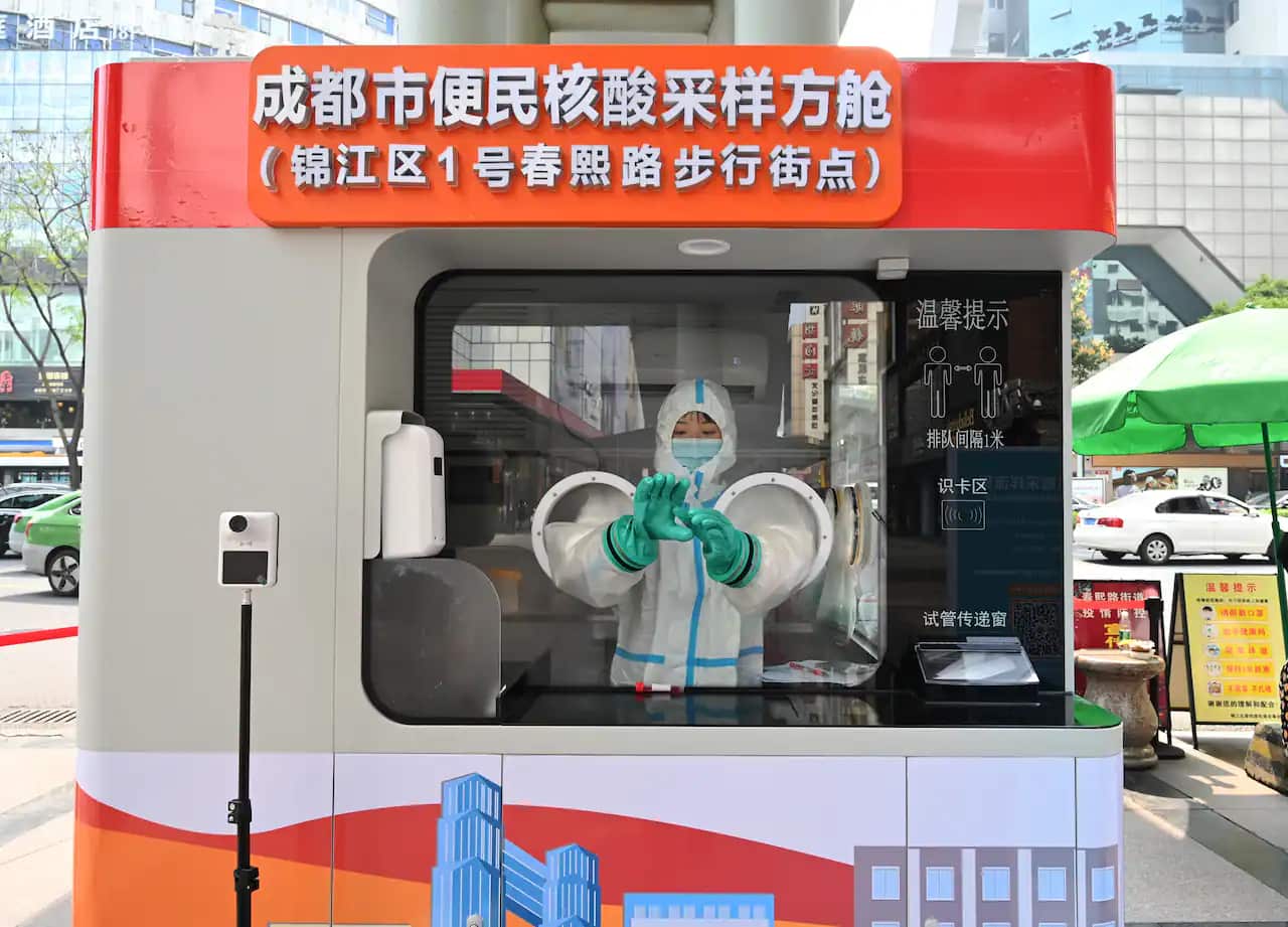 A medical worker stands in a portable coronavirus testing cabin set up at Chunxi Road Pedestrian Street on 15 March, 2022 in Chengdu, Sichuan Province of China.