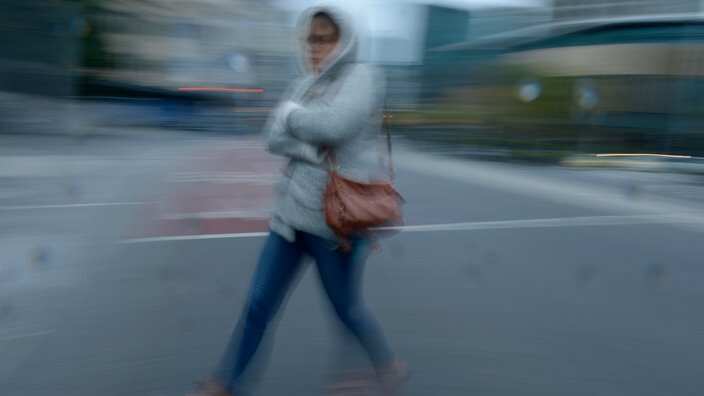 A woman rugs up as she walks through the city in Melbourne, Tuesday, May 12, 2015. (AAP Image/Tracey Nearmy) NO ARCHiVING