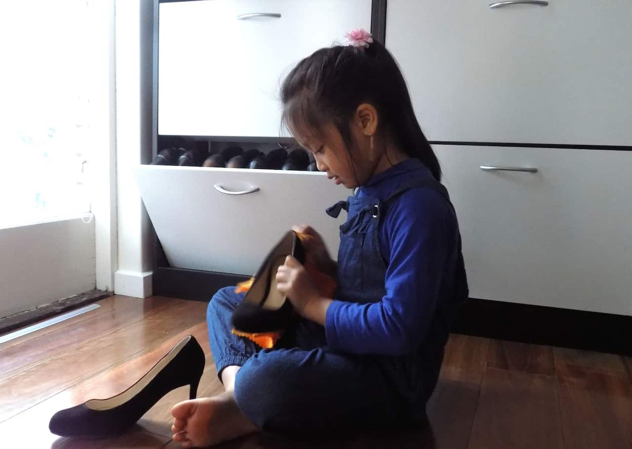 Con gái út của chị Lâm Anh Đào tự động lau đôi giày lấm lem của mẹ sau cơn mưa