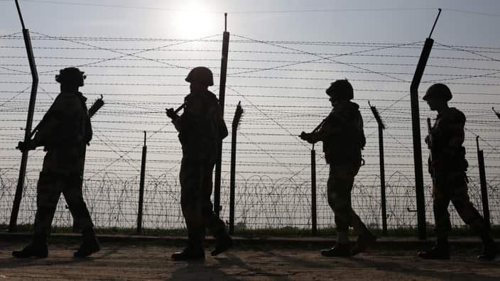 Indian Border Security Force (BSF) soldiers patrol along the fence somewhere at the India-Pakistan border, near Amritsar.