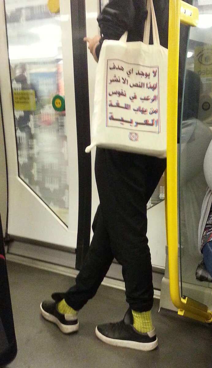 Text on bag reads as: "This text has no other purpose than to terrify those who are afraid of the Arabic language."