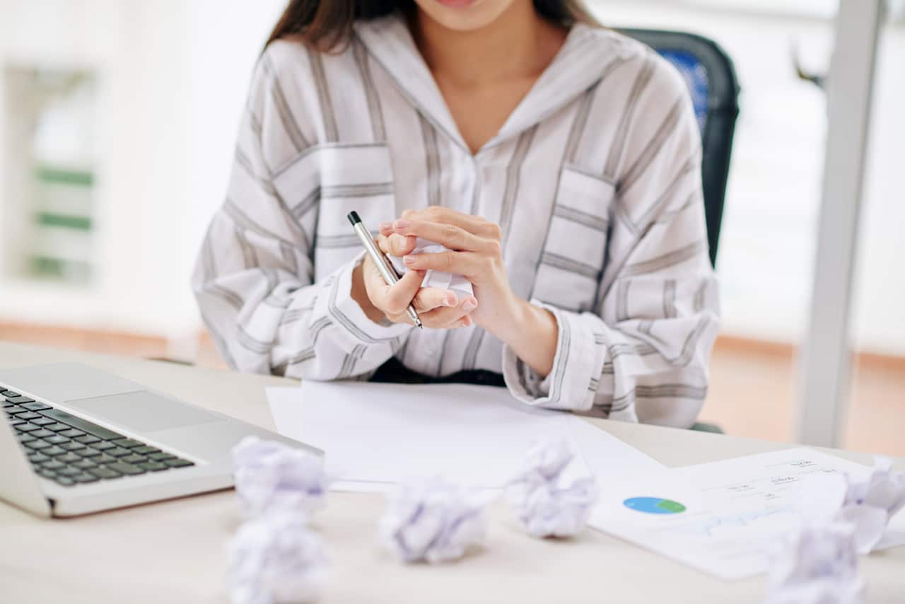 Crop businesswoman crumpling paper while writing