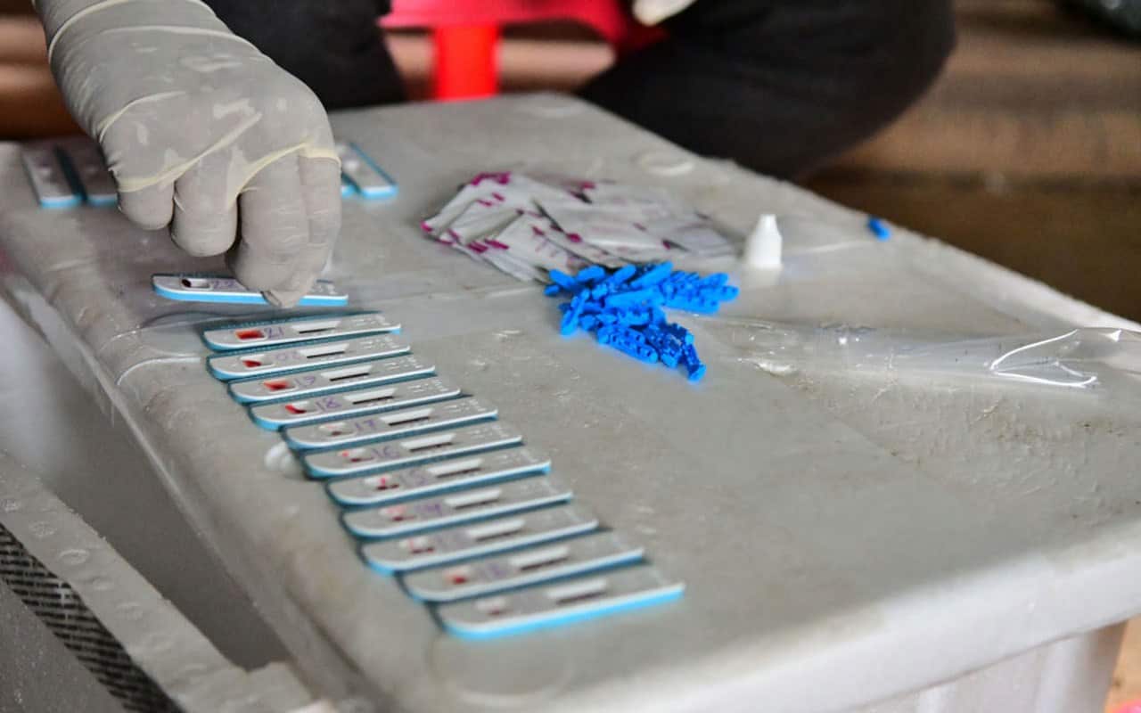 A health worker collects blood samples for HIV testing.
