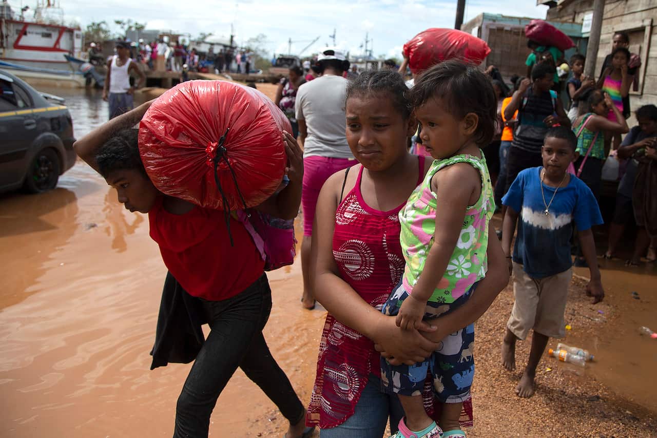People walk with their belongings as being evacuated by the army before the arrival of hurricane Iota on November in Puerto Cabezas, Nicaragua. 