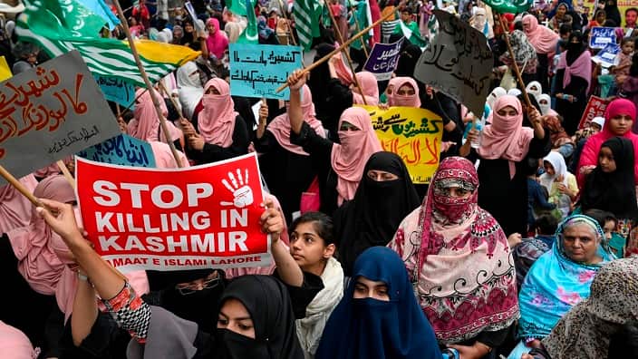 Supporters and activists of Jamaat-e-IslamiPakistan hold placards during a Kashmir march in Lahore on October 6, 2019. - Photo by ARIF ALI/AFP via Getty Images)