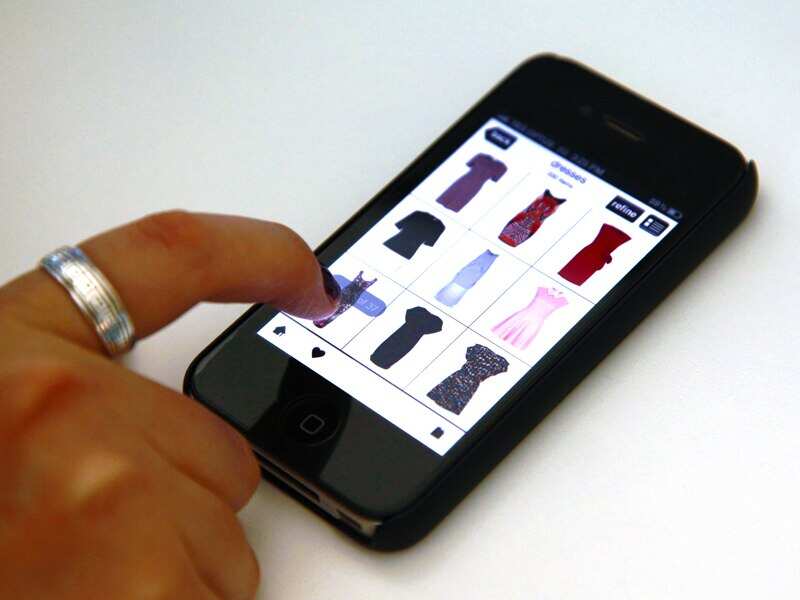 A woman browses an online clothing store on her iPhone