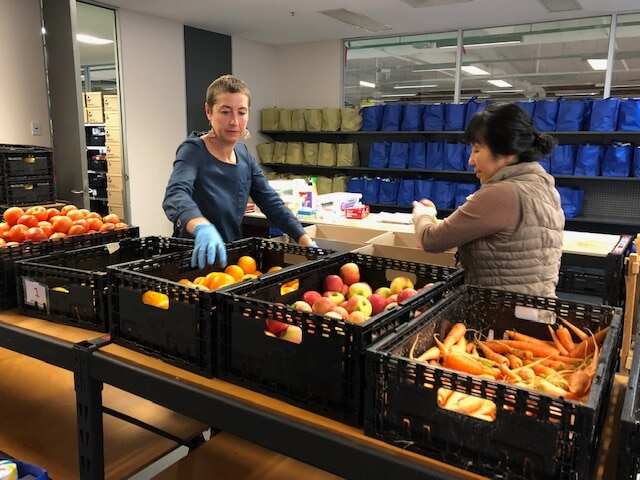 ASRC Jana Favero and a volunteer pack emergency relief food boxes