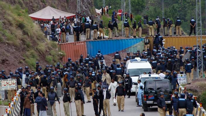 Policemen stand on top of shipping containers that block the JKLF supporters during a protest in Jaskool, Pakistani Kashmir, Oct. 7, 2019.(AP Photo/M.D. Mughal)