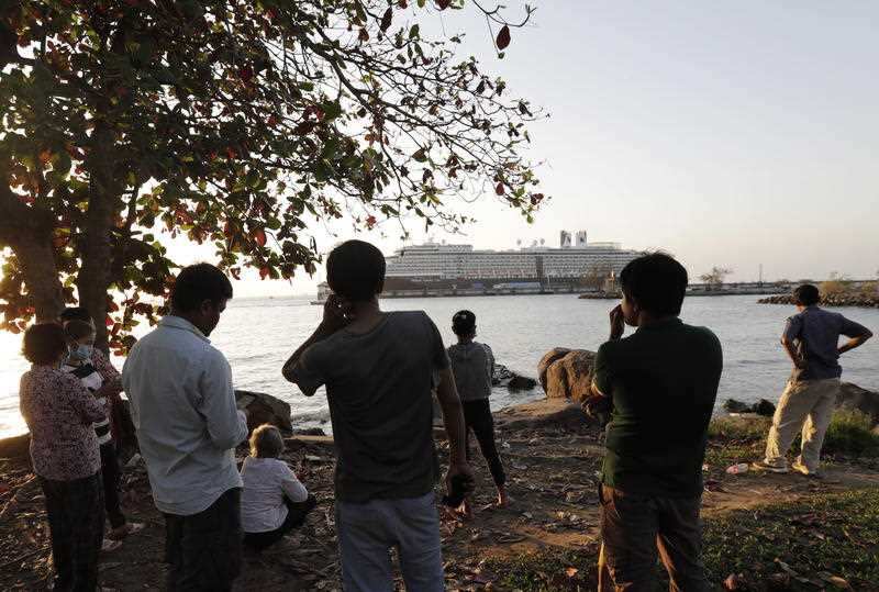Cambodian people look at the MS Westerdam cruise ship docking at a sea port in Preah Sihanouk province