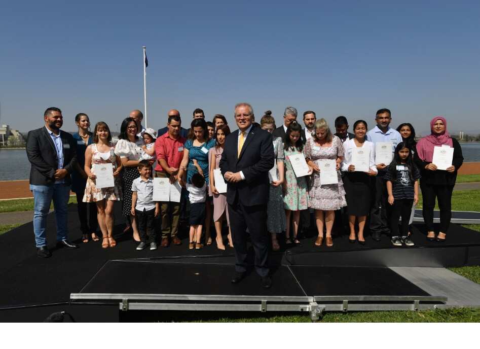 Prime Minister Scott Morrison poses for photos with new citizens during an Australia Day Citizenship Ceremony in Canberra.