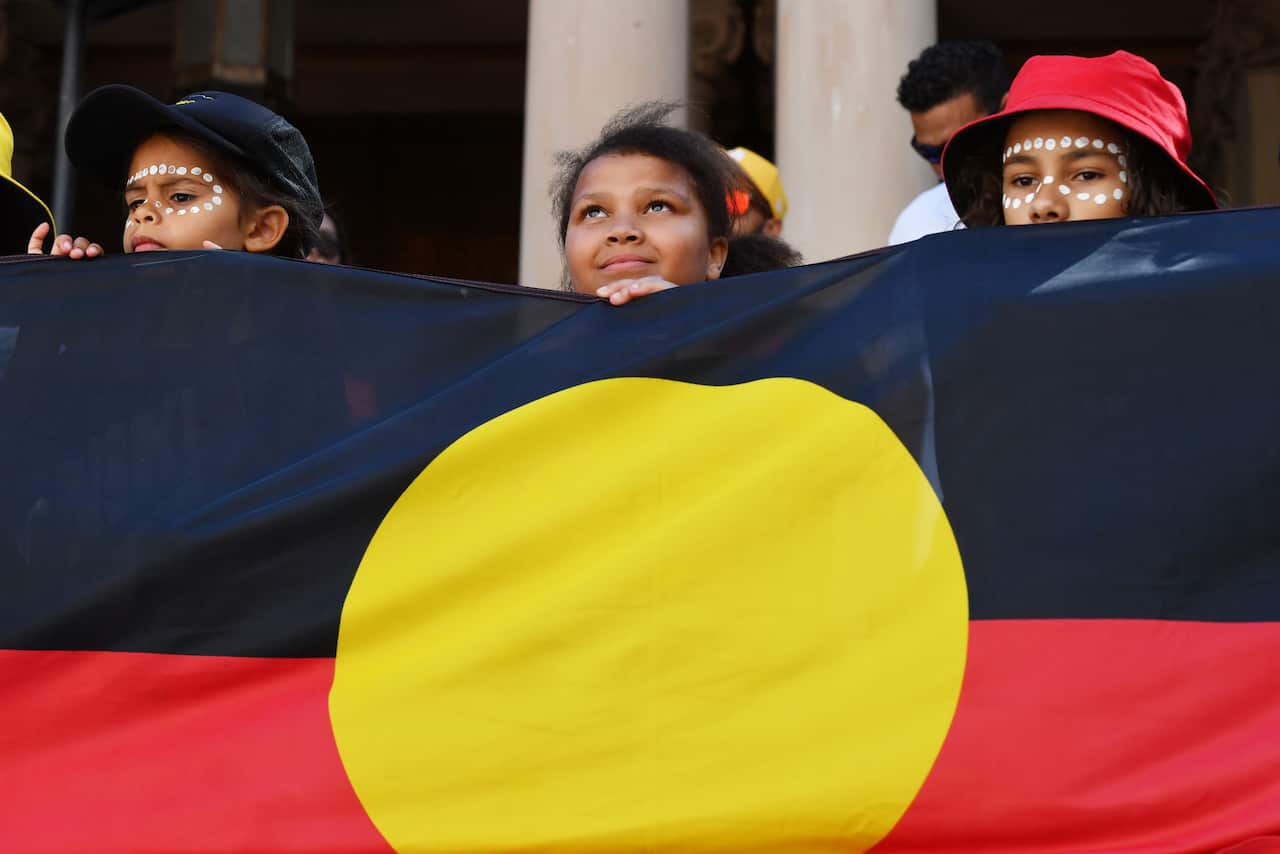 Children hold an indigenous flag at a Black Deaths in Custody Rally at Town Hall in Sydney, Saturday, April 10, 2021. 
