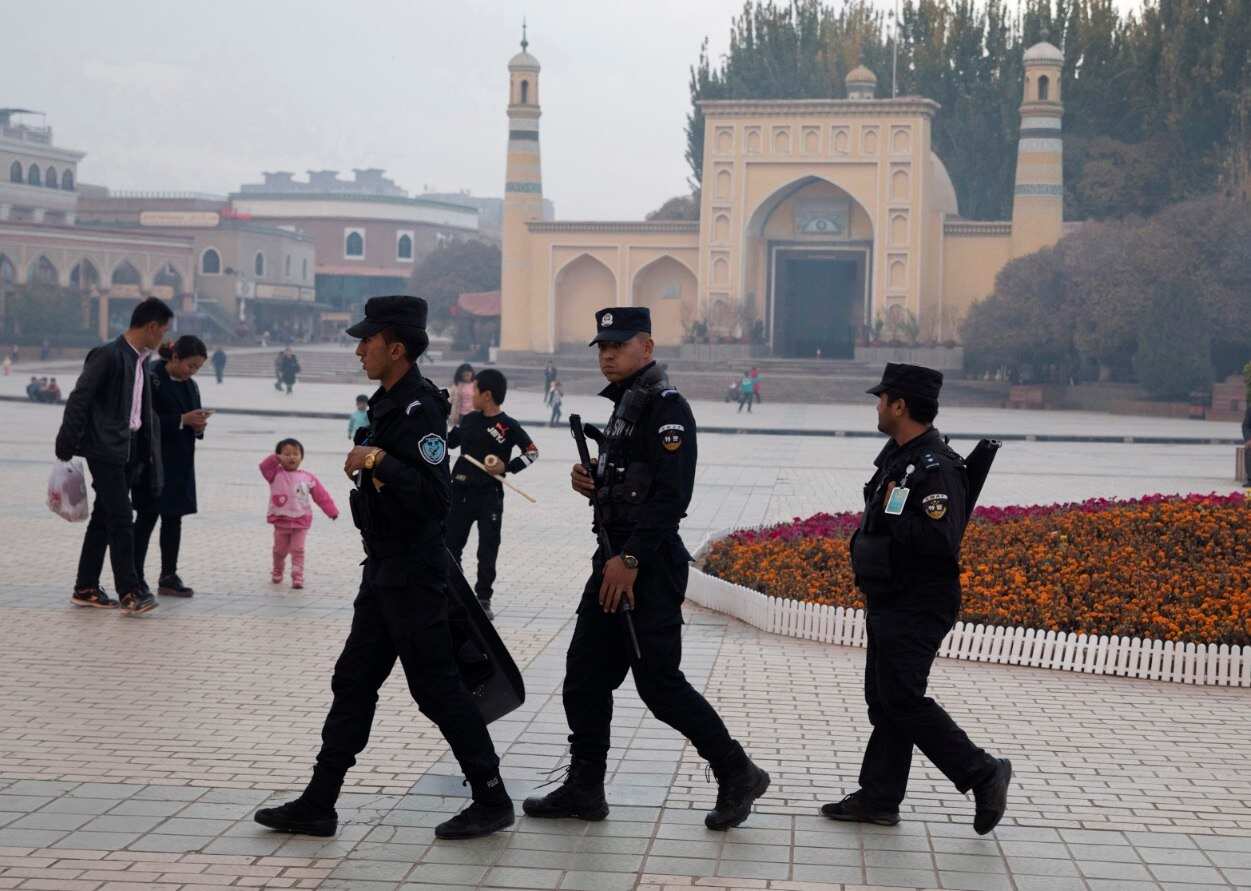 File photo, Uighur security personnel patrol near the Id Kah Mosque in Kashgar in western China's Xinjiang region