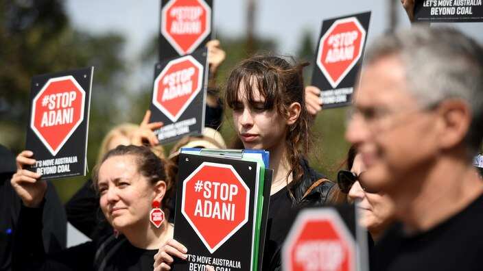 Anti-Adani supporters holding placards