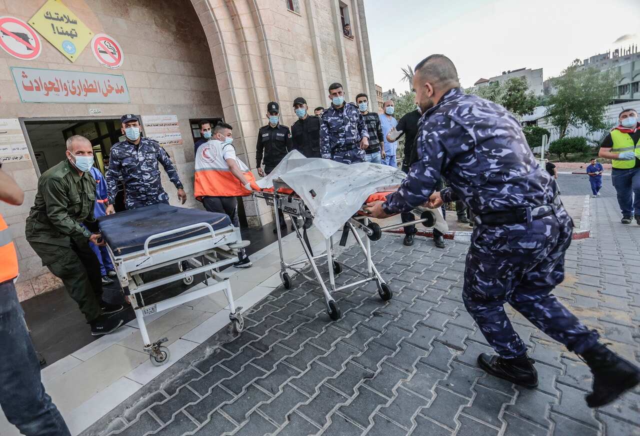 An injured Palestinian man is being brought to Al-Shifa hospital to receive treatment after an Israeli air strike in Gaza City. 