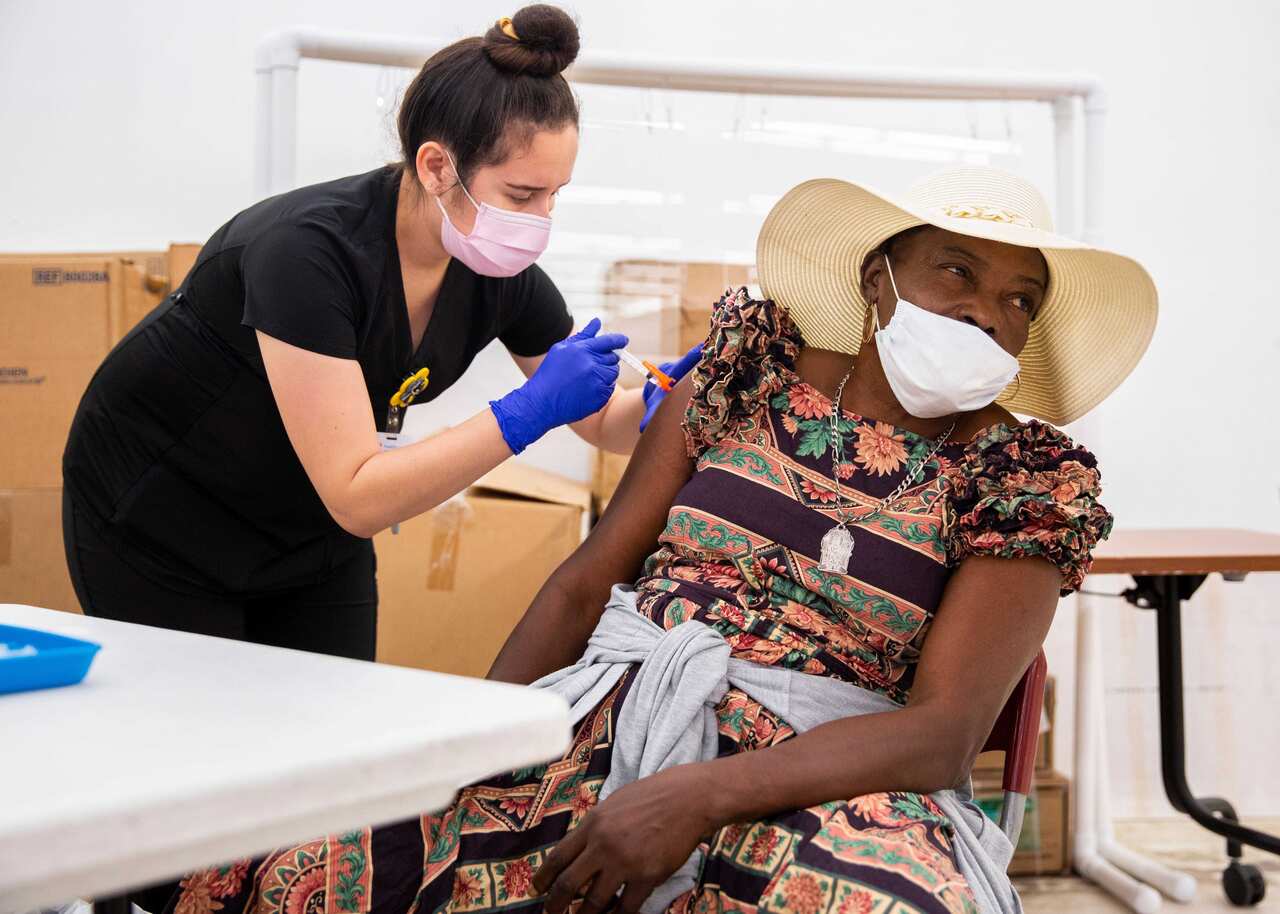 Lucy Delgado, Healthcare Network RN, vaccinates Polonne Colin at the Florida Department of Health in Immokalee