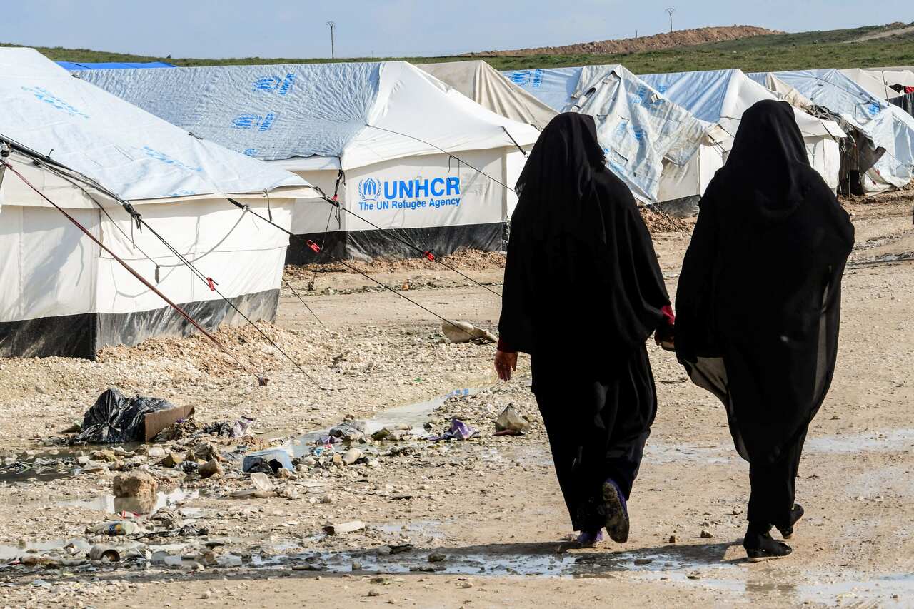 Veiled women, living in al-Hol camp which houses relatives of Islamic State (IS) group members, walk inside the camp in al-Hasakeh governorate.