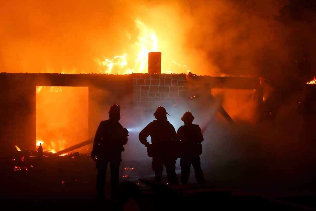 The wildfires spreading across California have so far claimed nine lives and forced tens of thousands to flee.