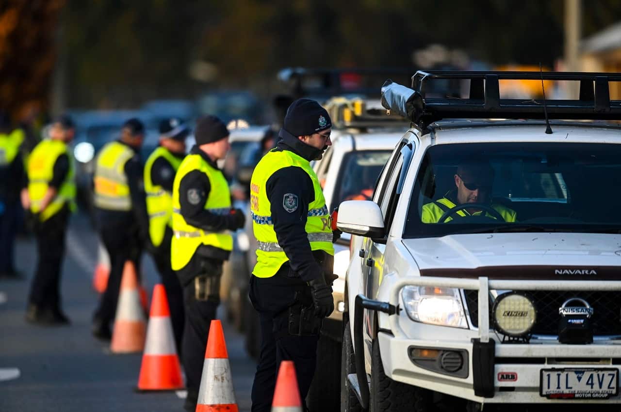 NSW Police officers check cars crossing from Victoria into New South Wales on Wednesday.