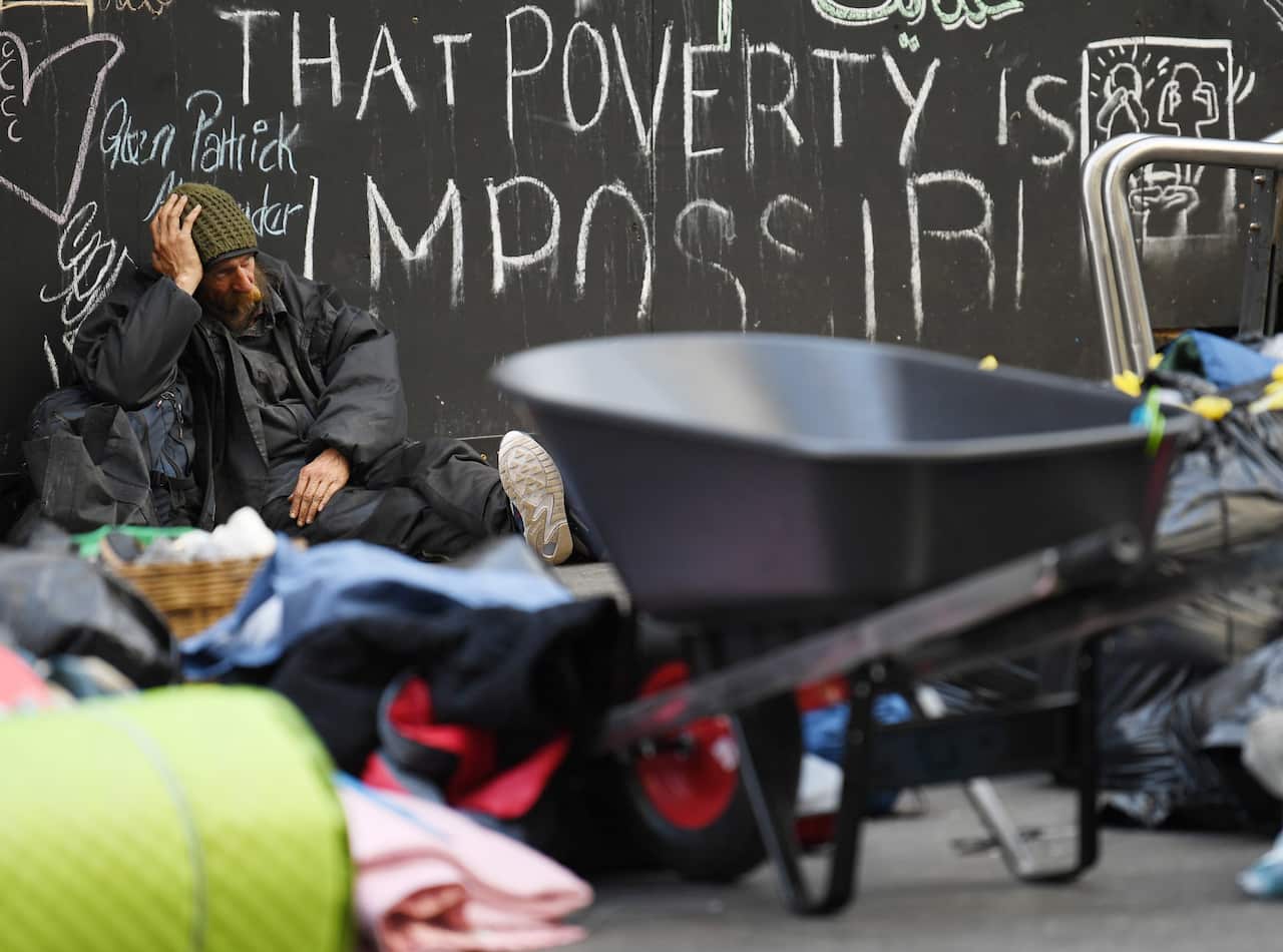 A homeless man sits on the ground in Sydney's Martin Place.