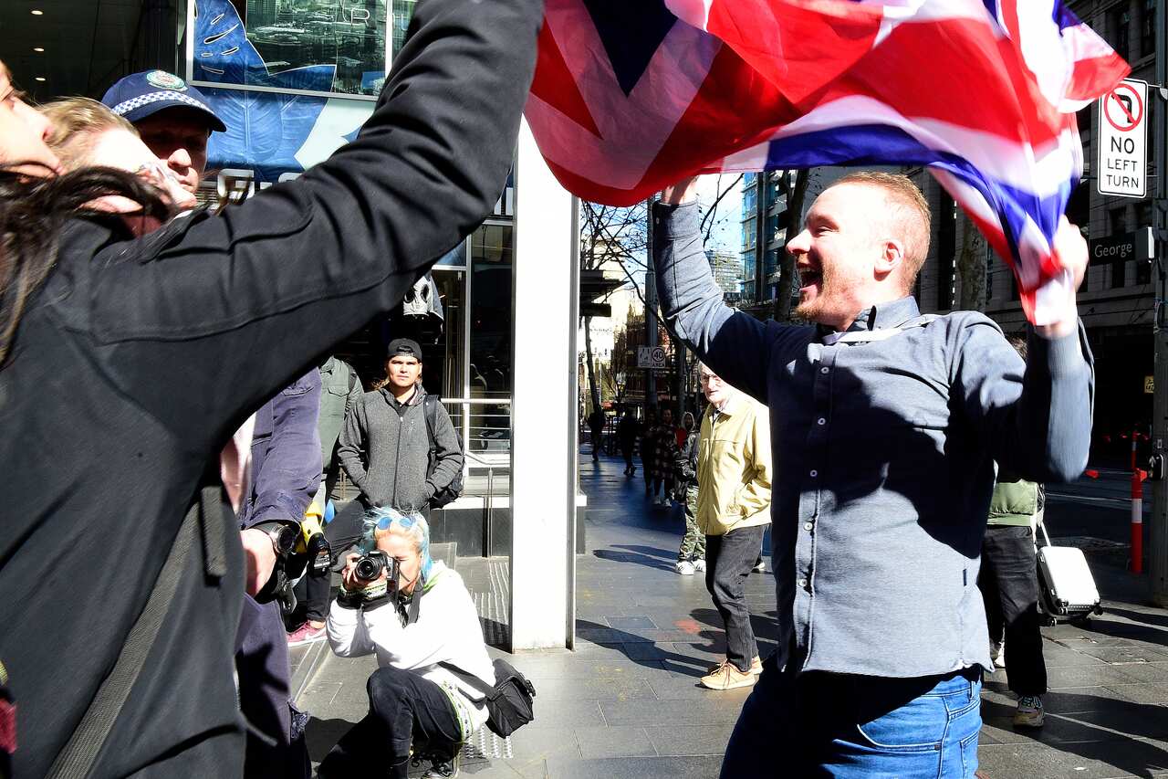 A conference attendee clashes with protestors outside the conference as police intervene. 