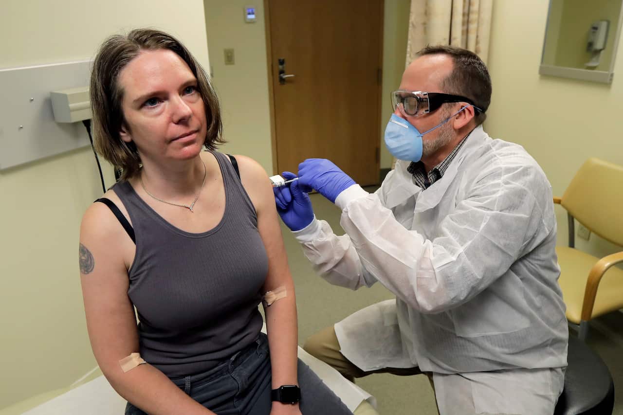 A woman in the US is given the first shot in the clinical trial of a potential vaccine for the COVID-19 coronavirus by a pharmacist.