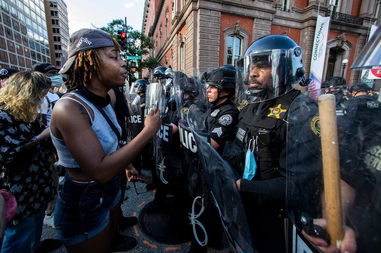Protesters confront police in riot gear near the White House in Washington.      