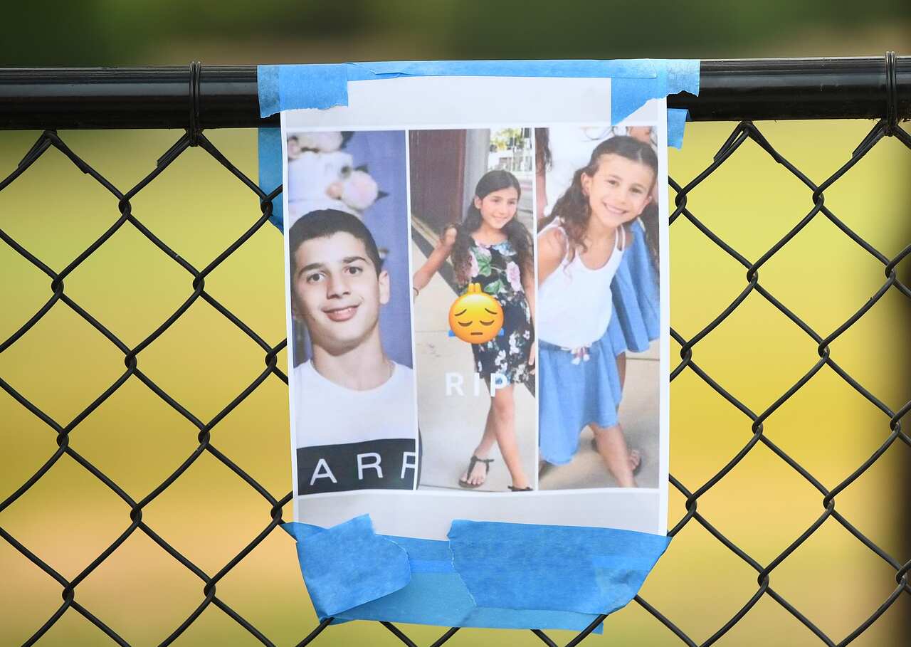 Photos of three victims were hung among a floral tribute at the scene of the crash.