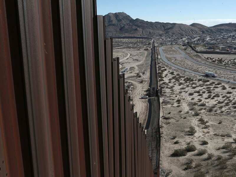 A truck drives near the Mexico-US border fence