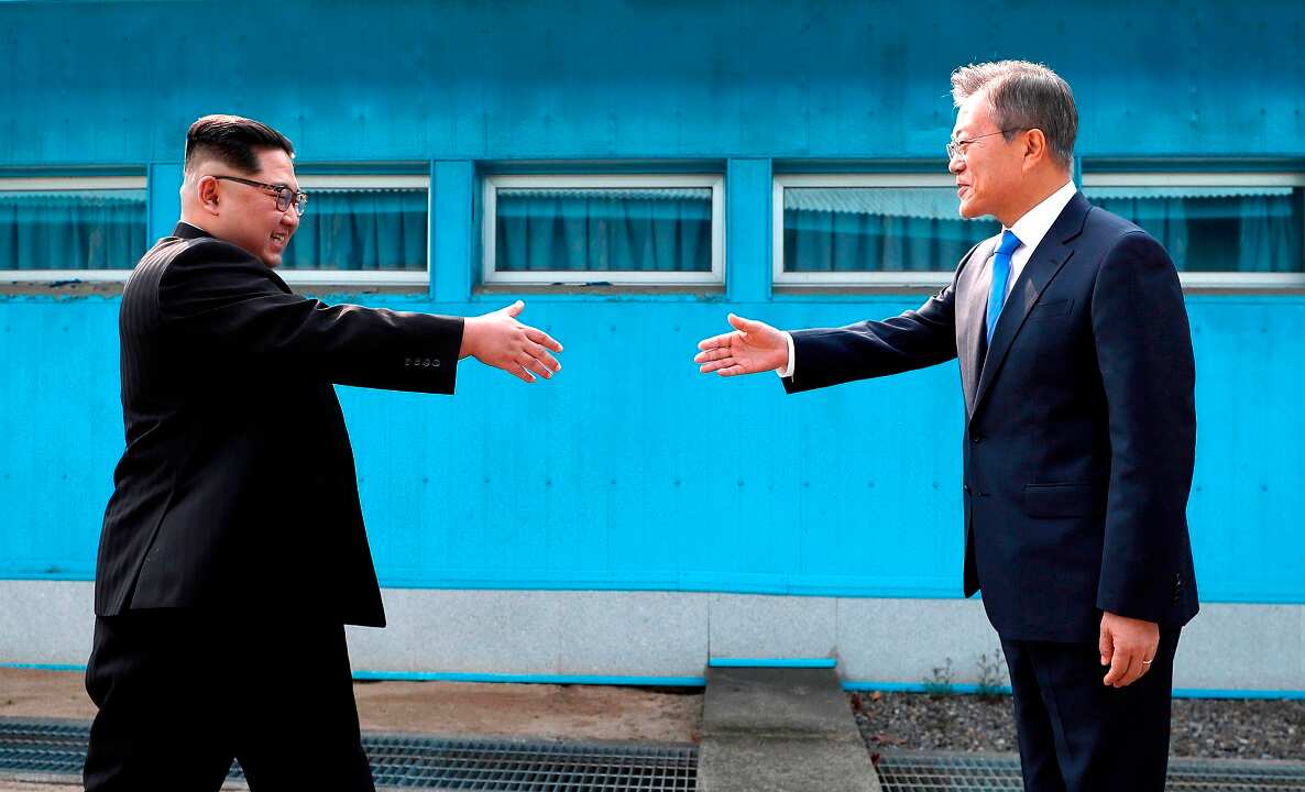 The historic moment when the two leaders prepare to shake hands.