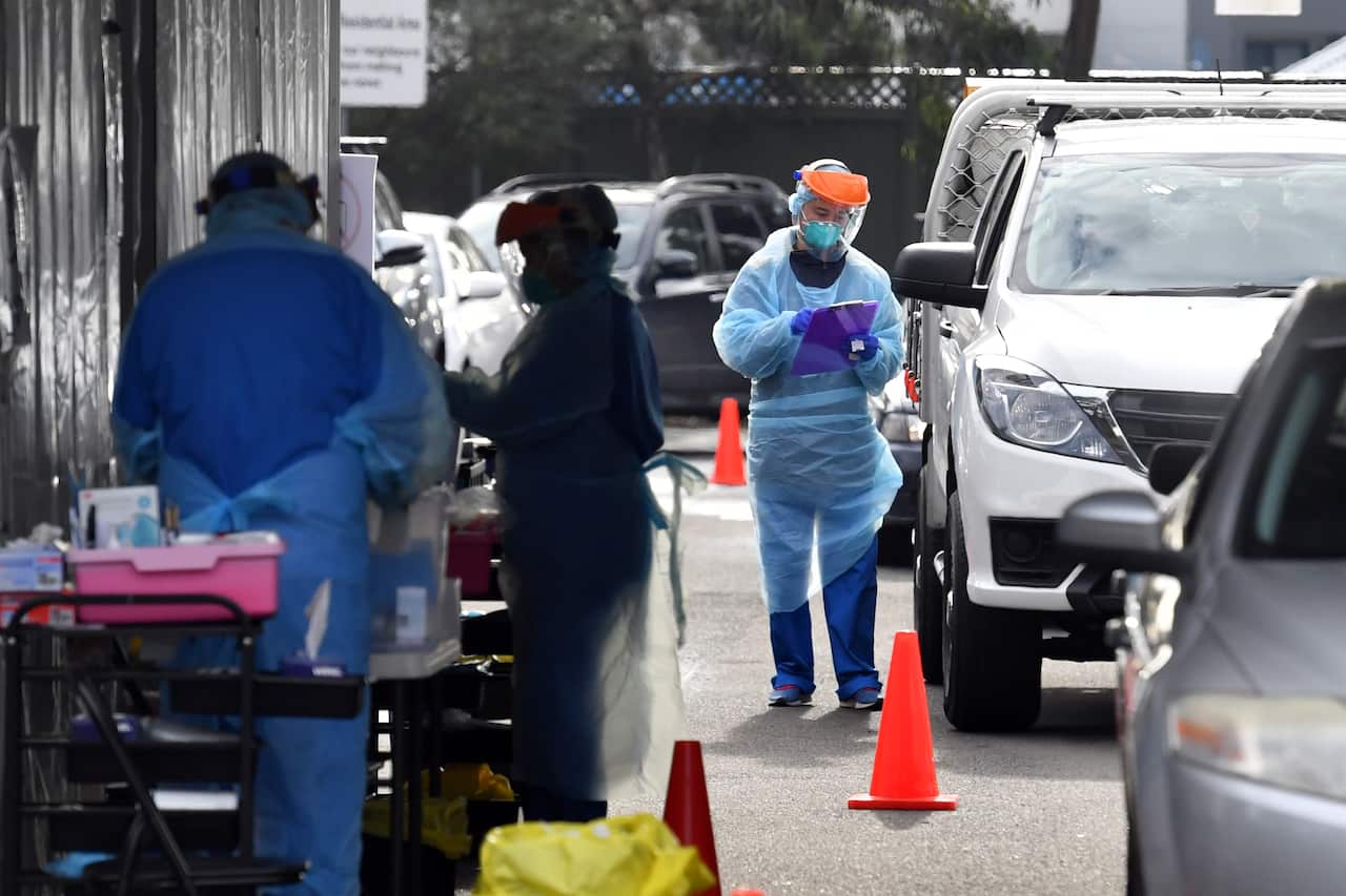 Health workers are seen at a pop up COVID-19 testing clinic at the Blacktown Showgrounds
