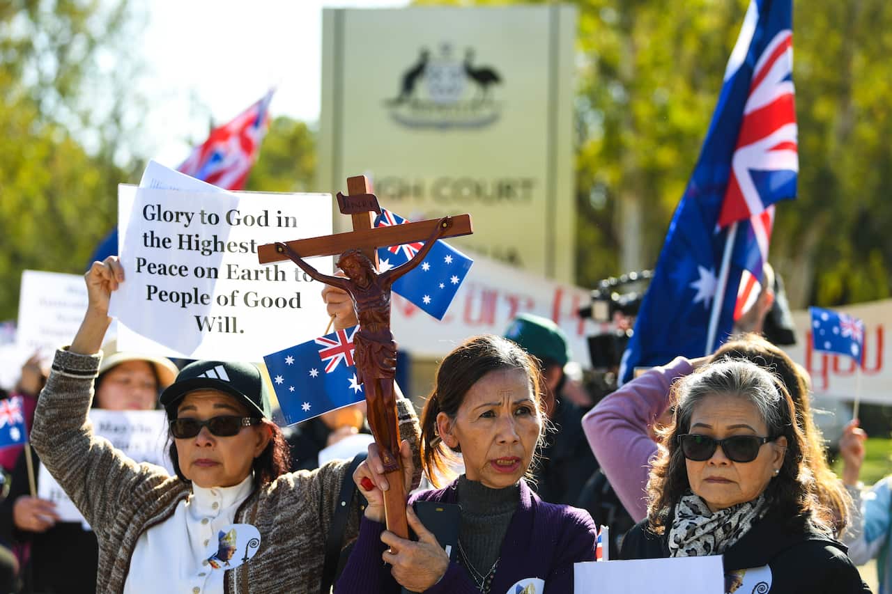 Supporters of George Pell pray outside the High Court of Australia in Canberra, Wednesday, March 11, 2020. 