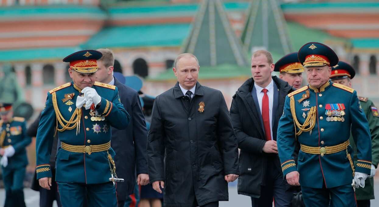 Russian President Vladimir Putin (C) and Russian Defence Minister Sergei Shoigu (L) walk along the Red Square after the Victory Day military parade in Moscow