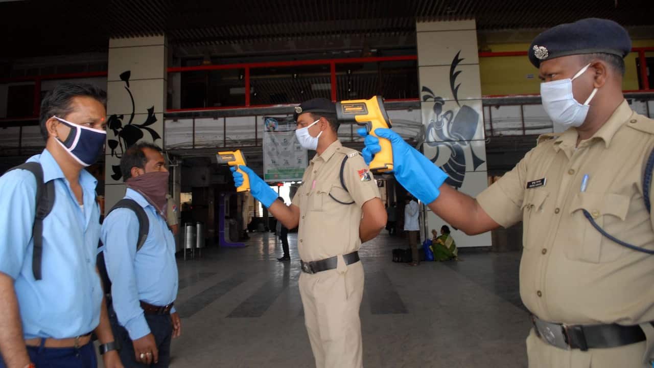 Security person checks temperature of Passengers during a one-day Janata (civil) curfew imposed as a preventive measure against the COVID-19 in Kolkata. 22.3.20