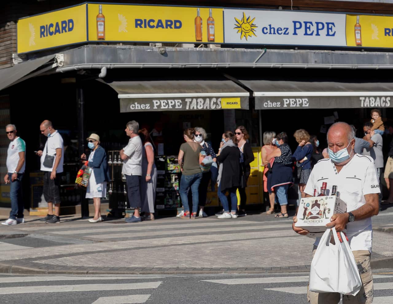 Travellers waiting in line at shops and markets located at the Spanish-French border.