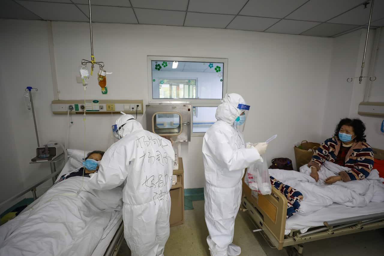 Medical officers tend to two patients inside Jinyintan Hospital, Wuhan where critical coronavirus patients are quarantined.