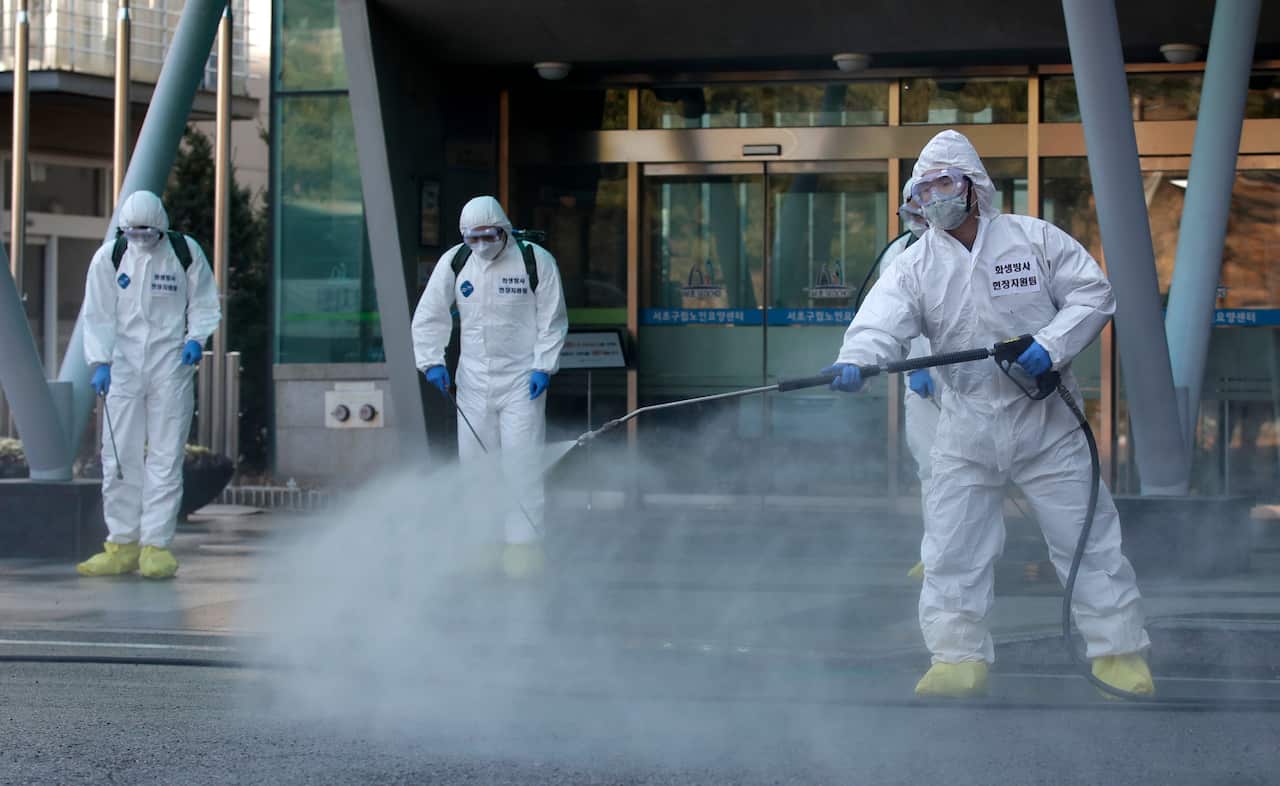 South Korean soldiers wearing protective gears spray disinfectant as a precaution against the new coronavirus in Seoul