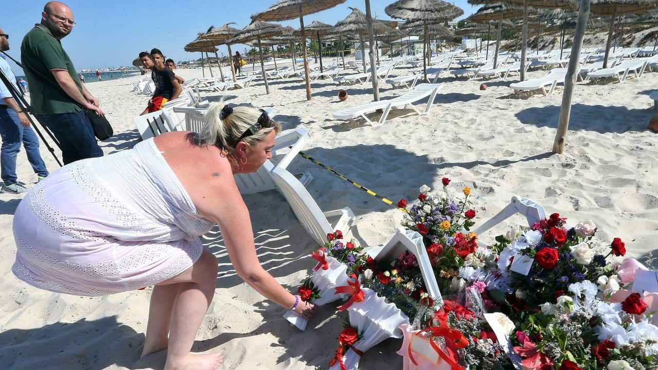 A person places flowers in tribute to those killed in a terror attack on tourists on a beach in front of the Imperial Marhaba Hotel in al-Sousse.