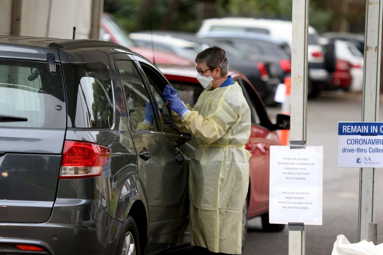 A nurse takes a sample at a drive-in coronavirus testing station in Adelaide