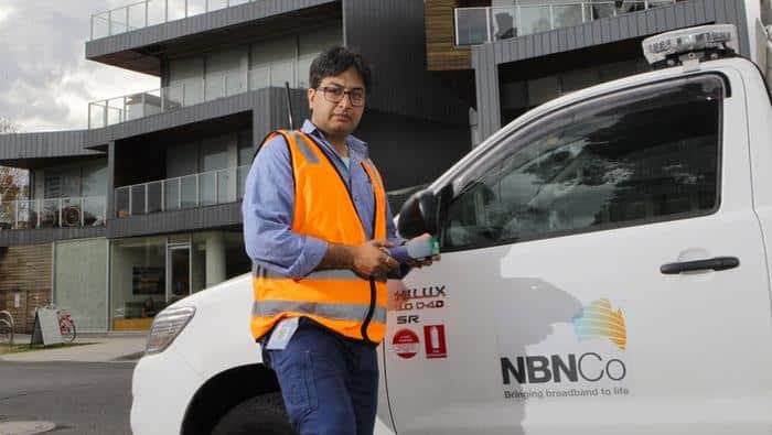 NBN technician Rajav Kapil in front of an apartment block that has been connected to the National Broadband Network (NBN) in Brunswick, Melbourne, Tuesday, March 11, 2014. (AAP Image/David Crosling) NO ARCHIVING