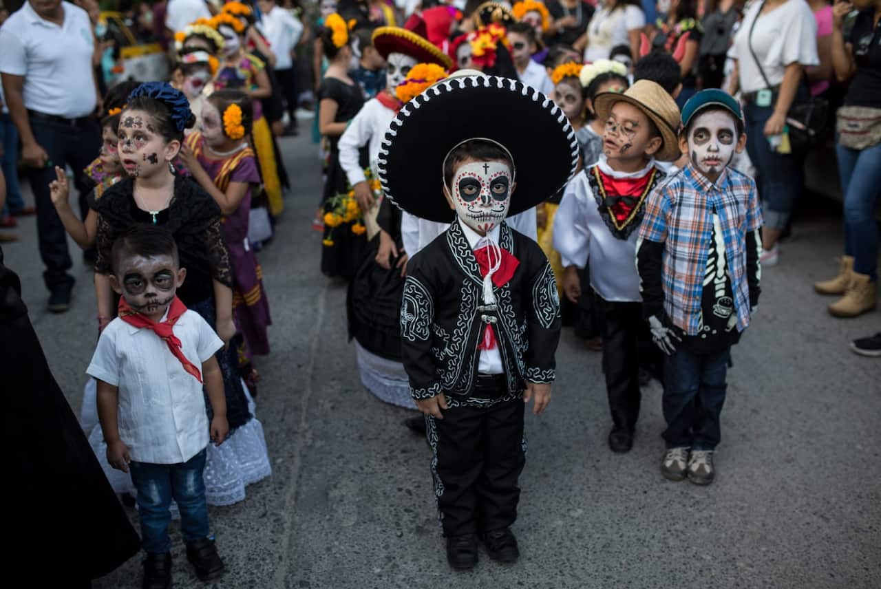 Children in costume gather for the start of a parade marking Day of the Dead in Juchitan, Mexico, Wednesday, Oct. 31, 2018