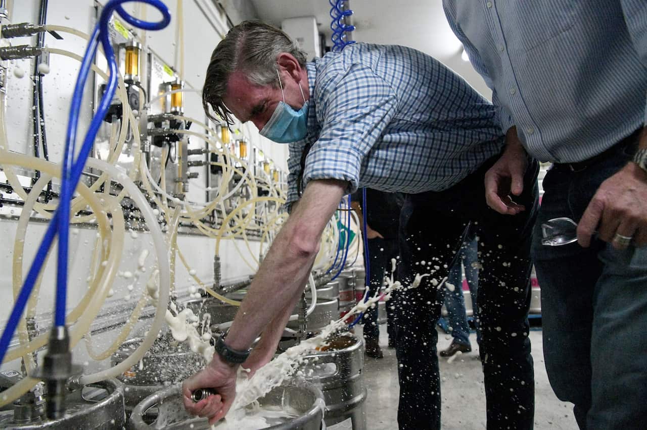 NSW Premier Dominic Perrottet taps a beer keg during a tour of the Marsden Brewhouse in Marsden Park, Sydney.