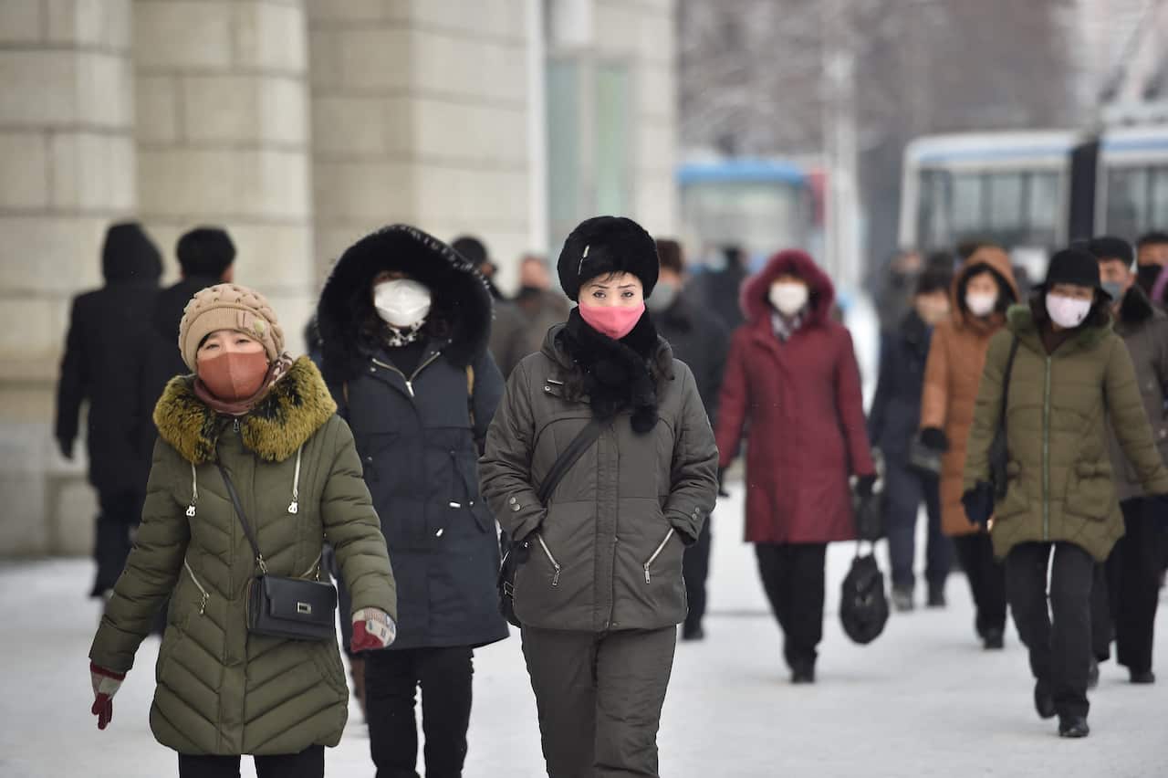Pedestrians walk on a street near Pyongyang Railway Station after a snowfall in Pyongyang on January 19, 2022. (Photo by KIM Won Jin / AFP) (Photo by KIM WON JIN/AFP via Getty Images)