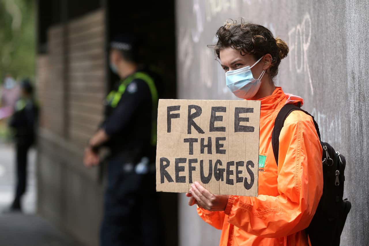 A protester holds a banner outside the Park Hotel 