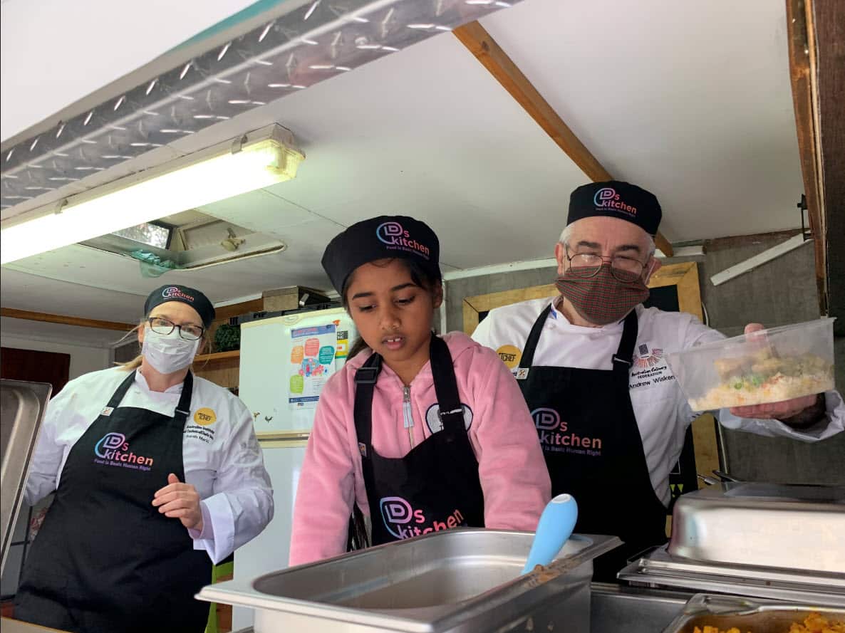 Diya helping with cooking and serving along with volunteers