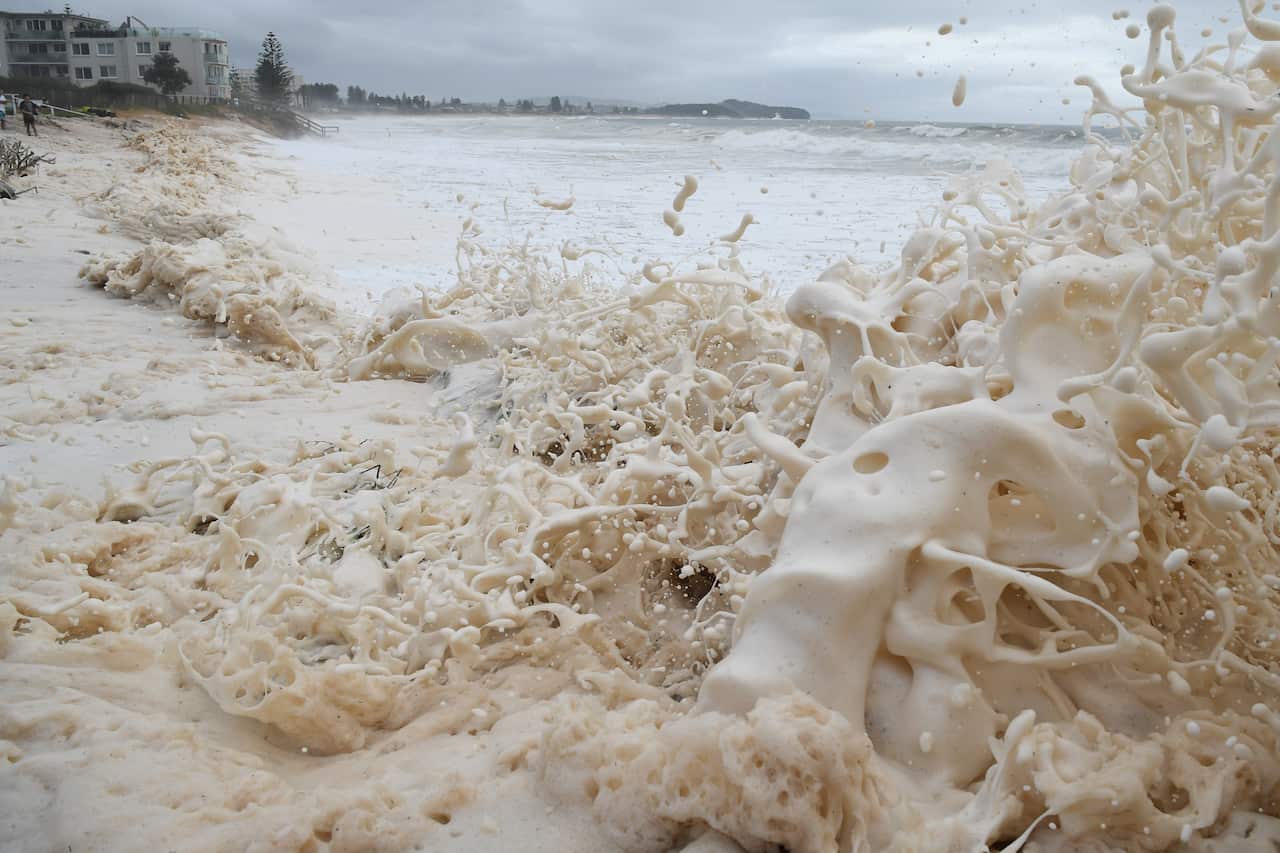 Sea foam brought by waves approaches on beach front houses after heavy rain and storms at Collaroy in Sydney's Northern Beaches.